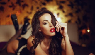 Striptease show performer in Budapest on a bed with erotic lingerie and special atmoshphere.