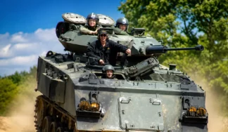Tank driving experience in Budapest with a group riding a tracked military vehicle