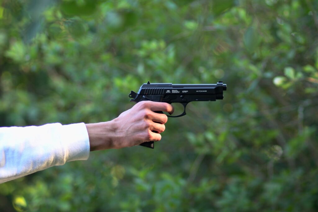 A man shooting with a 9mm gun in Budapest in the woods. It is an outdoor shooting range.