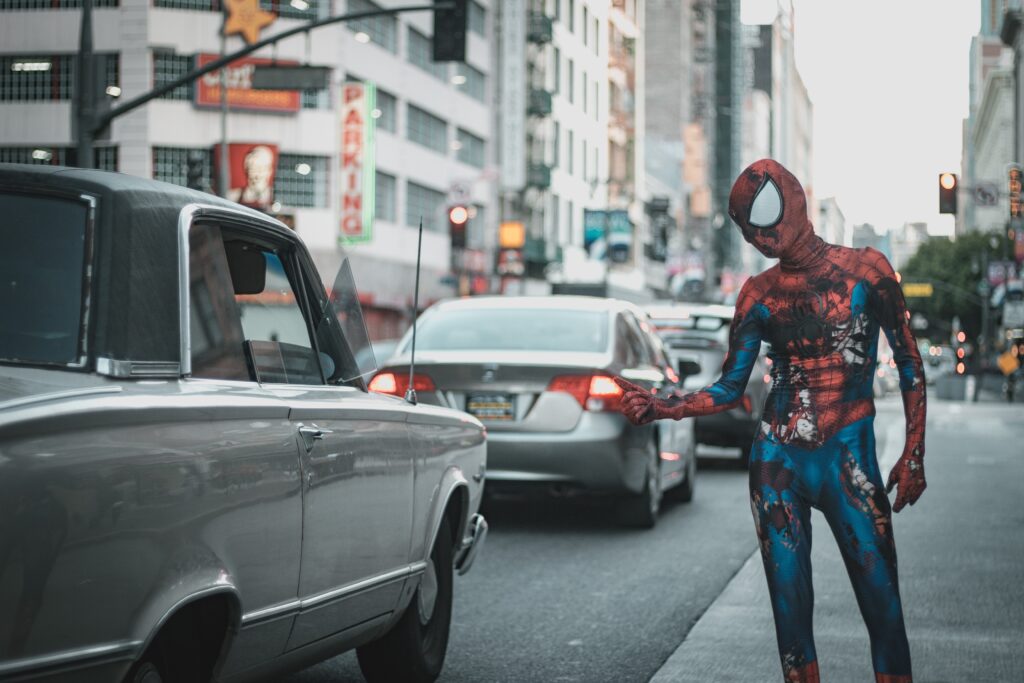 fancy spiderman dressed up stag in the traffic of Budapest trying to sell unusual things.