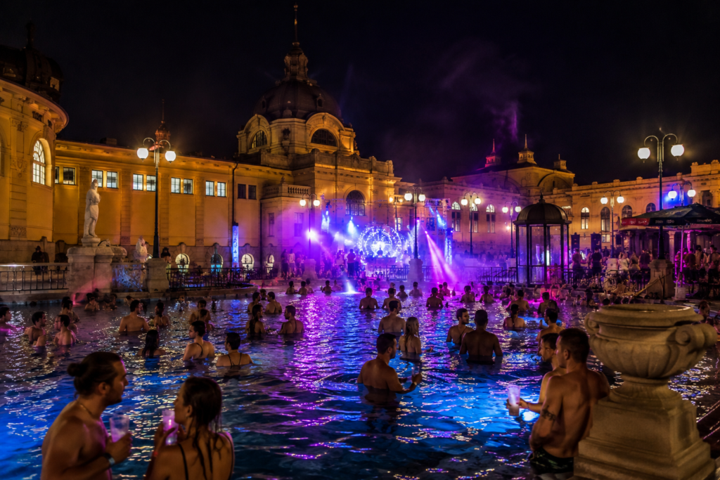 Nighttime thermal bath party in Budapest with music and poolside lights