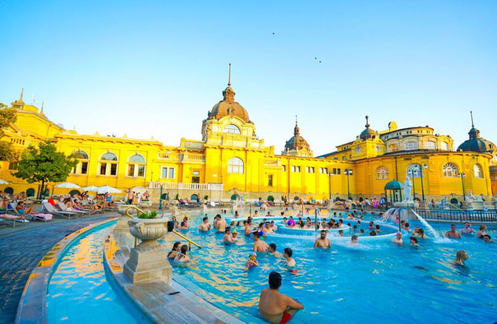 Visitors enjoying Széchenyi Thermal Baths in Budapest, a perfect recovery spot for a Budapest vs Prague stag do.