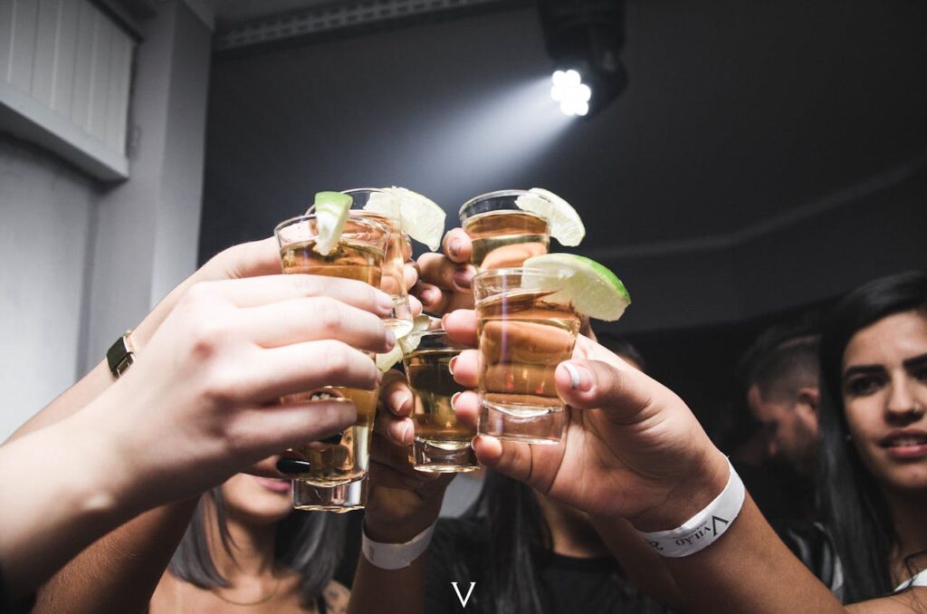 Group of friends raising tequila shots during a Budapest nightlife experience.