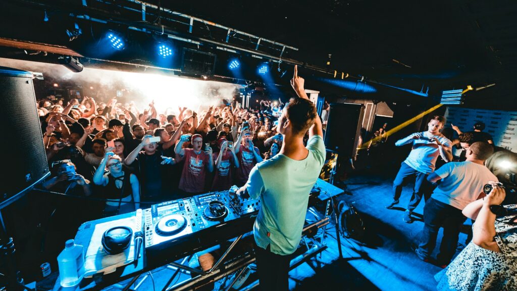 DJ playing to a packed nightclub crowd during a VIP stag do night in Budapest.