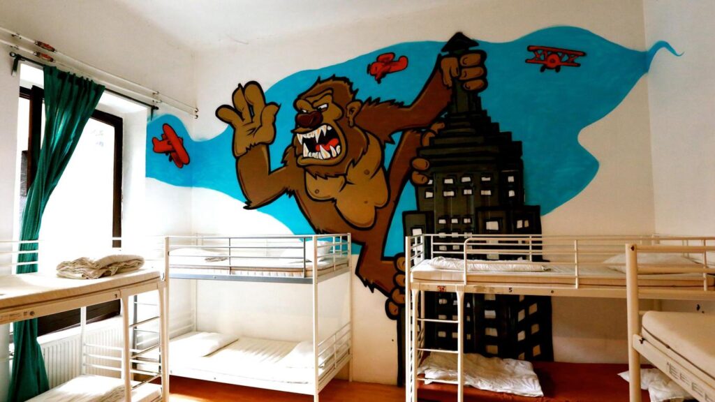 Colorful dorm room at Retox Party Hostel in Budapest, featuring vibrant wall art and bunk beds, ideal for affordable bachelor party accommodation.