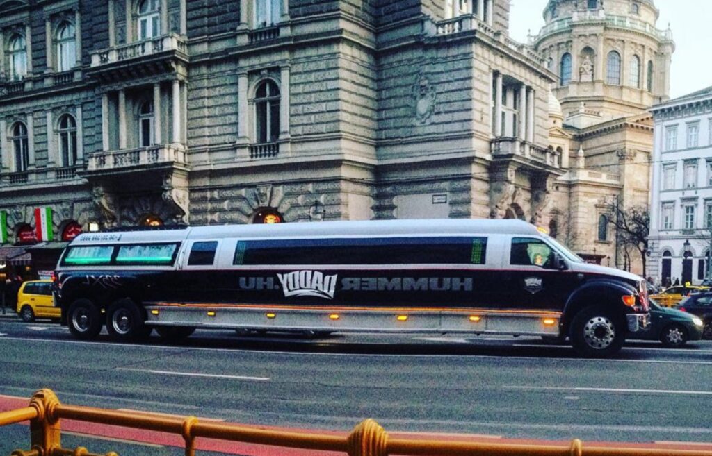 Hummer limo XXL for stag do transfer Budapest, cruising past historic architecture, perfect for large groups and luxurious celebrations