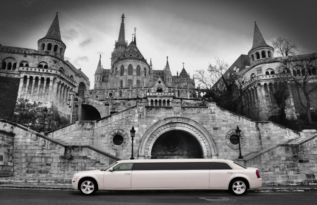 Chrysler limo for stag do transfer Budapest, parked near historic Fisherman's Bastion, offering a stylish and luxurious travel option.