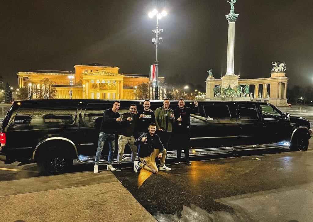 Group enjoying a VIP stag do transfer in Budapest with a luxury black limo at Heroes’ Square, perfect for unforgettable celebrations.