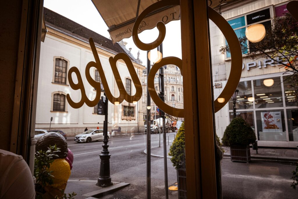 View from a cozy café window in Budapest's Jewish Quarter, showcasing the lively streets and historic architecture, ideal for visitors exploring local culture and nightlife.