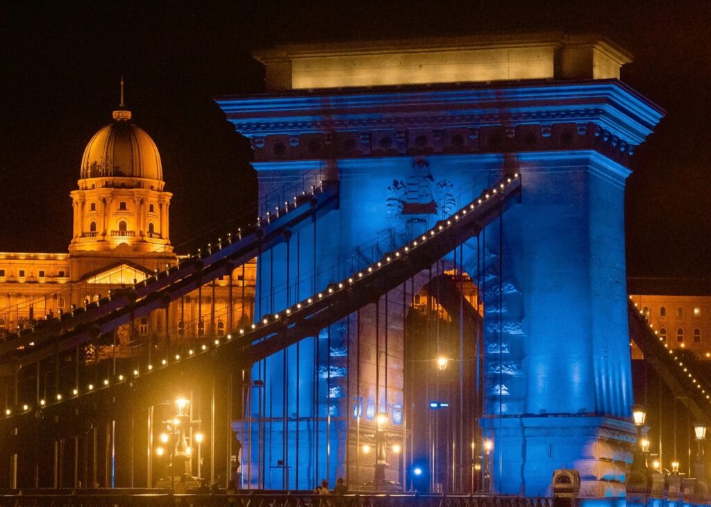 Budapest’s Chain Bridge illuminated in vibrant colors at night, showcasing the city’s enchanting atmosphere—ideal for an unforgettable stag do in Europe.