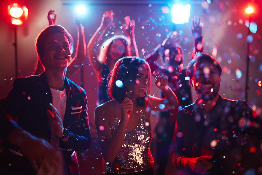 Guests dancing and celebrating during a vibrant Private Riverboat Party, with confetti and colorful lights creating an unforgettable atmosphere.