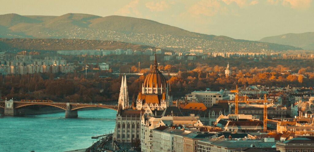 A stunning view of Budapest with the Hungarian Parliament, the Danube River, and surrounding hills, highlighting the vibrant cityscape perfect for stag activities and bachelor party adventures.