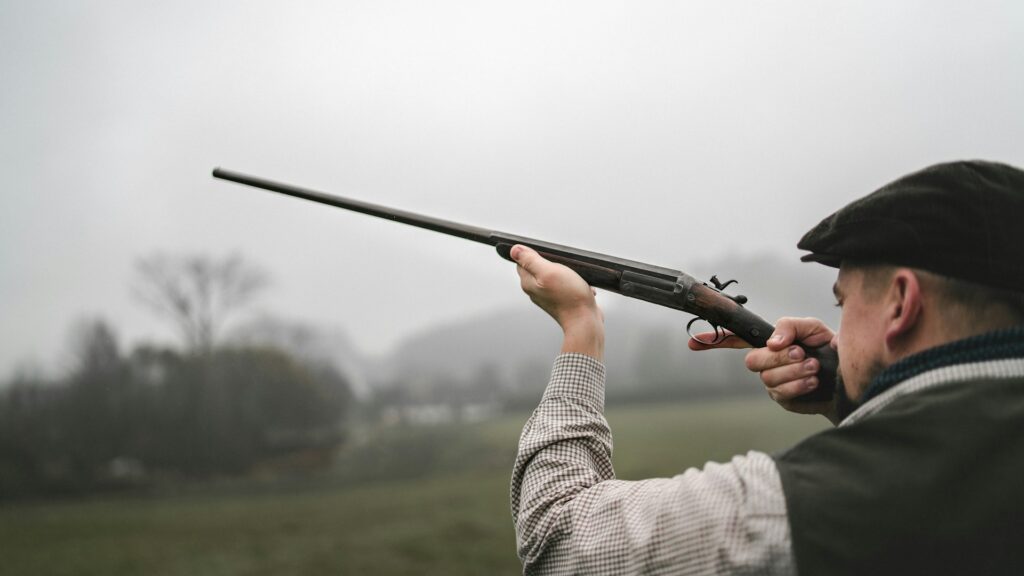 A man aiming a shotgun during a clay pigeon shooting activity, a thrilling option for Outdoor Adventures Stag Budapest experiences.