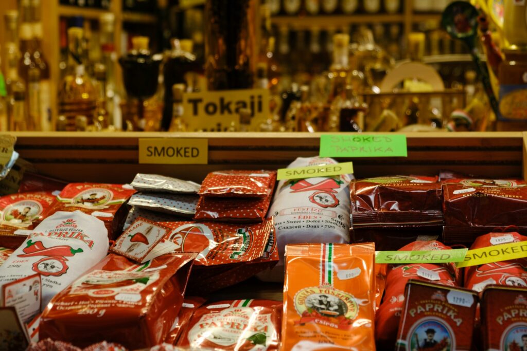 Hungarian gastronomy in Budapest with a colorful display of smoked paprika packages and traditional spices at a local market, showcasing authentic Hungarian flavors.