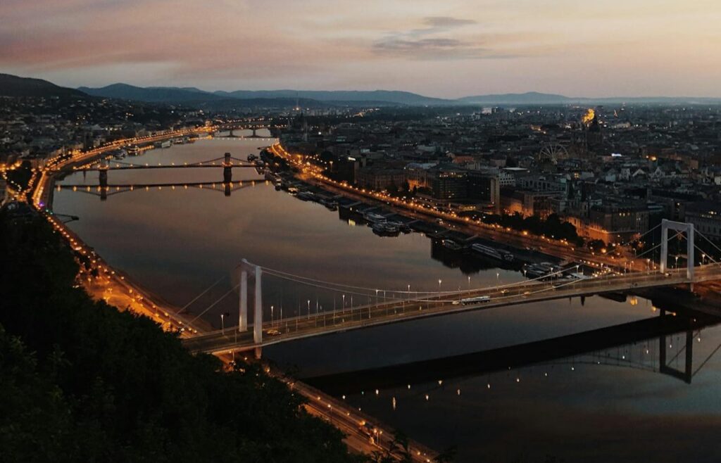 A breathtaking view of Budapest at dusk, showcasing the illuminated bridges and the calm Danube River, perfect for a serene evening experience.