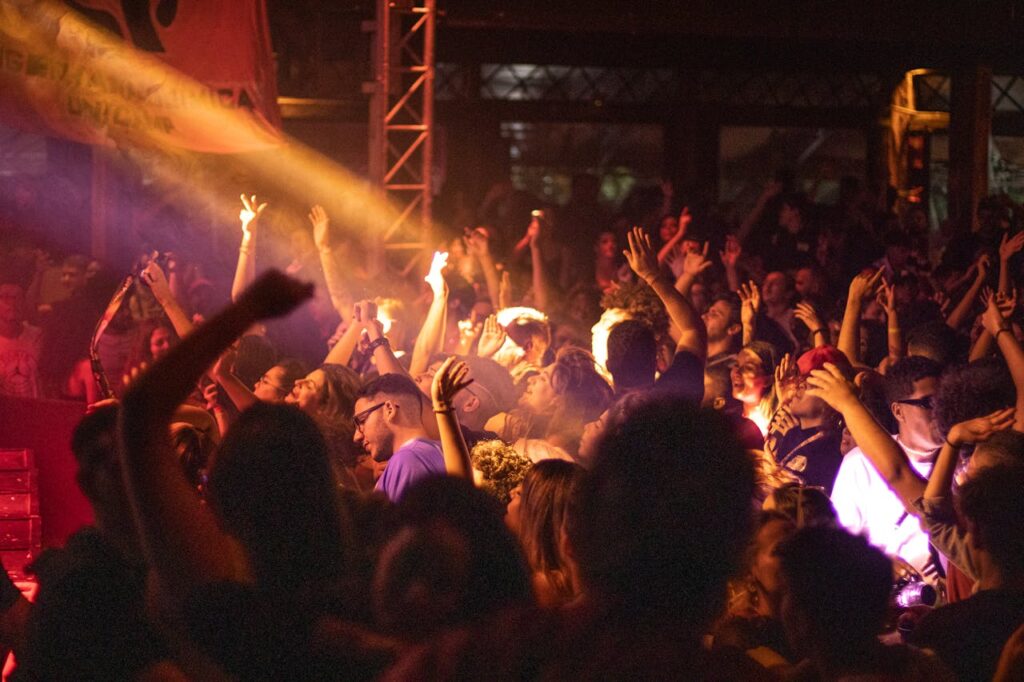 A vibrant and modern nightclub interior with colorful lights, a DJ booth, and a lively dance floor filled with people enjoying the music.